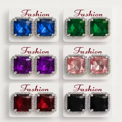 Close-up of a single purple emerald cut crystal stud earring with intricate silver filigree.