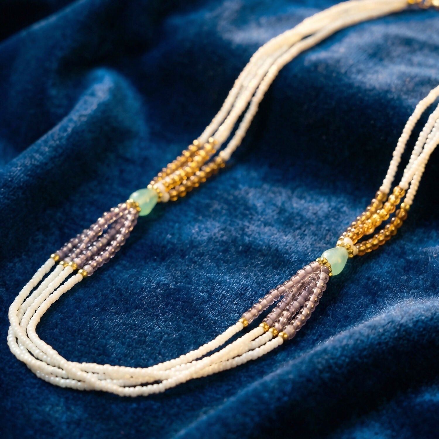 Close-up of gold and lavender beads on pearl necklace