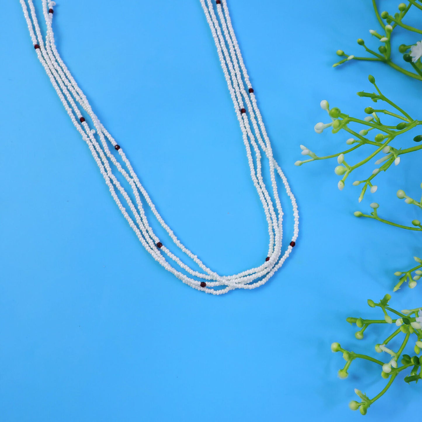 Side view of multi-layer pearl mala necklace with subtle red beads