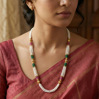 Close-up of layered beads in green, white and pink with gold detailing
