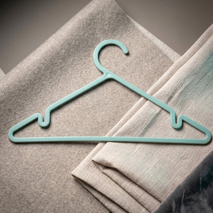 Plastic hanger holding shirt and dress