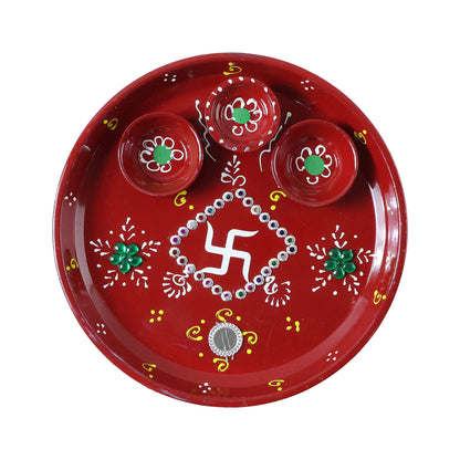 Three diyas arranged on hand-painted pooja thali