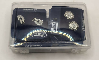 Display of four pairs of sterling silver stud earrings including butterfly, floral, heart, and peacock designs