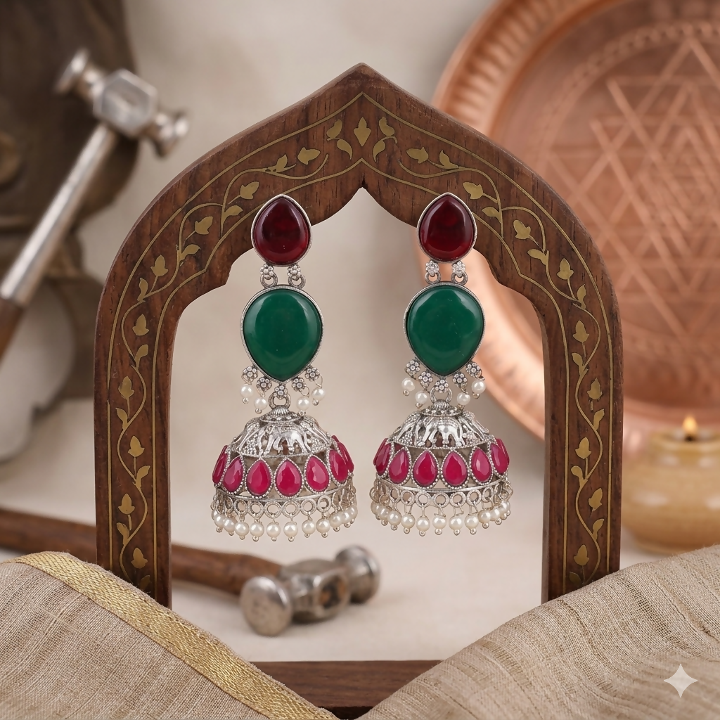 Close-up of oxidised silver jhumka earring showing intricate elephant design & pearl drops