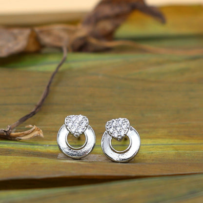Close-up of silver tone heart stud earrings with pave cubic zirconia stones