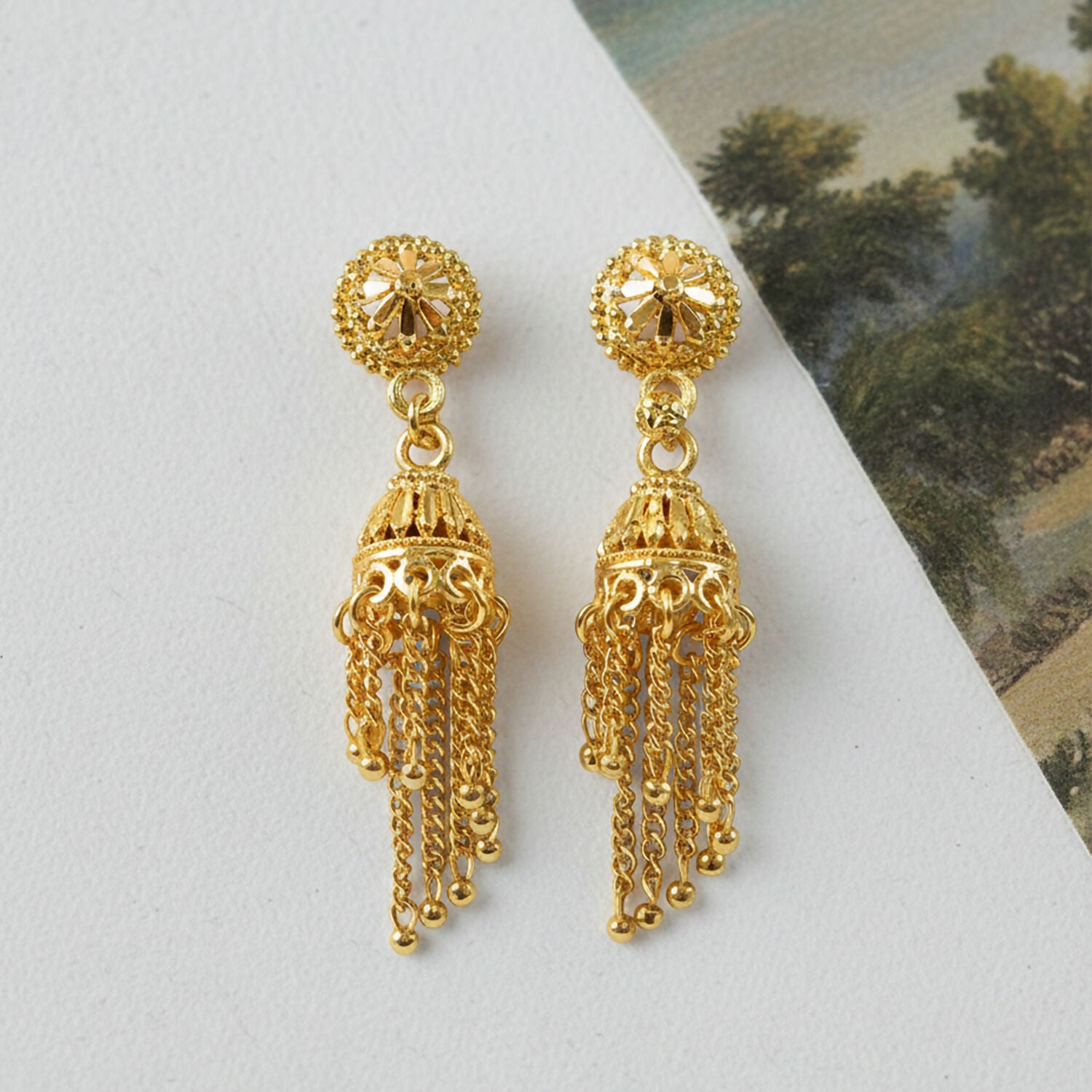 Front view of gold plated long chain tassel jhumka earrings