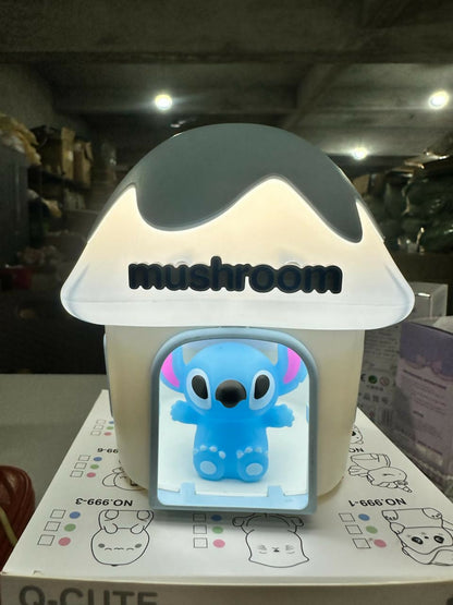 A mushroom house night light with a blue Stitch character, sitting on a patterned box in a warehouse setting.