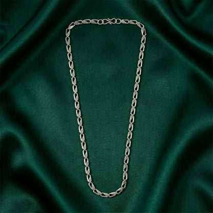 Silver designer chain necklace displayed on a dark background