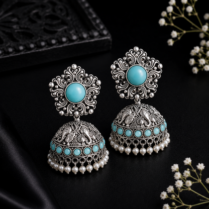 Close-up of floral stud with light blue stone on jhumka earrings