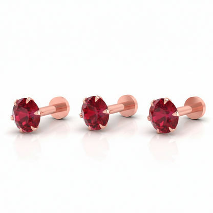 Three rose gold nose studs with flat backs and bright ruby red cubic zirconia set in prong settings