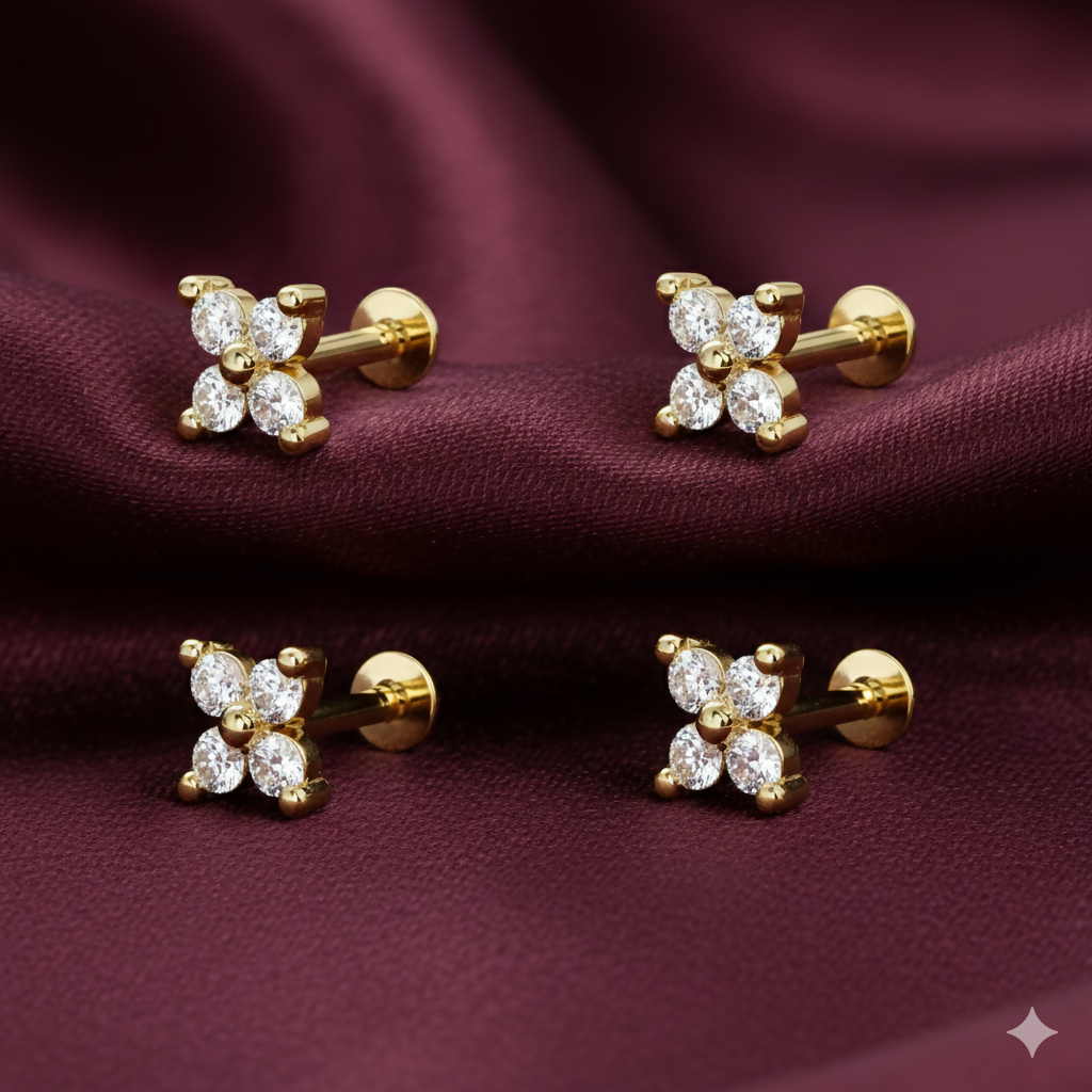 Close-up of gold plated four-petal clover labret nosepin stud showing cubic zirconia detail