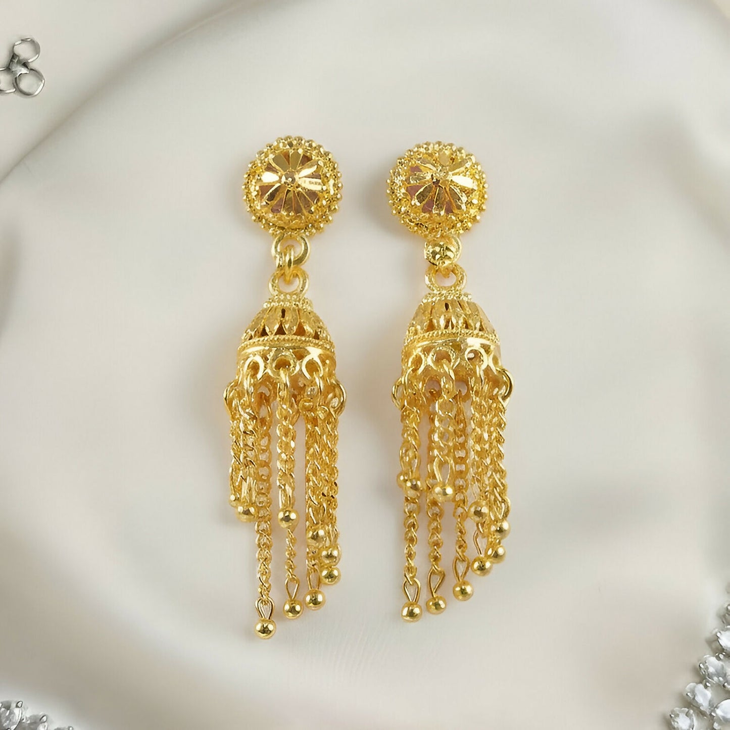 Close-up of intricate design on gold plated jhumka earrings