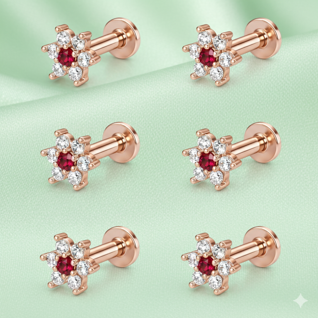 Close-up of rose gold floral stud earring with vibrant ruby center and crystal halo