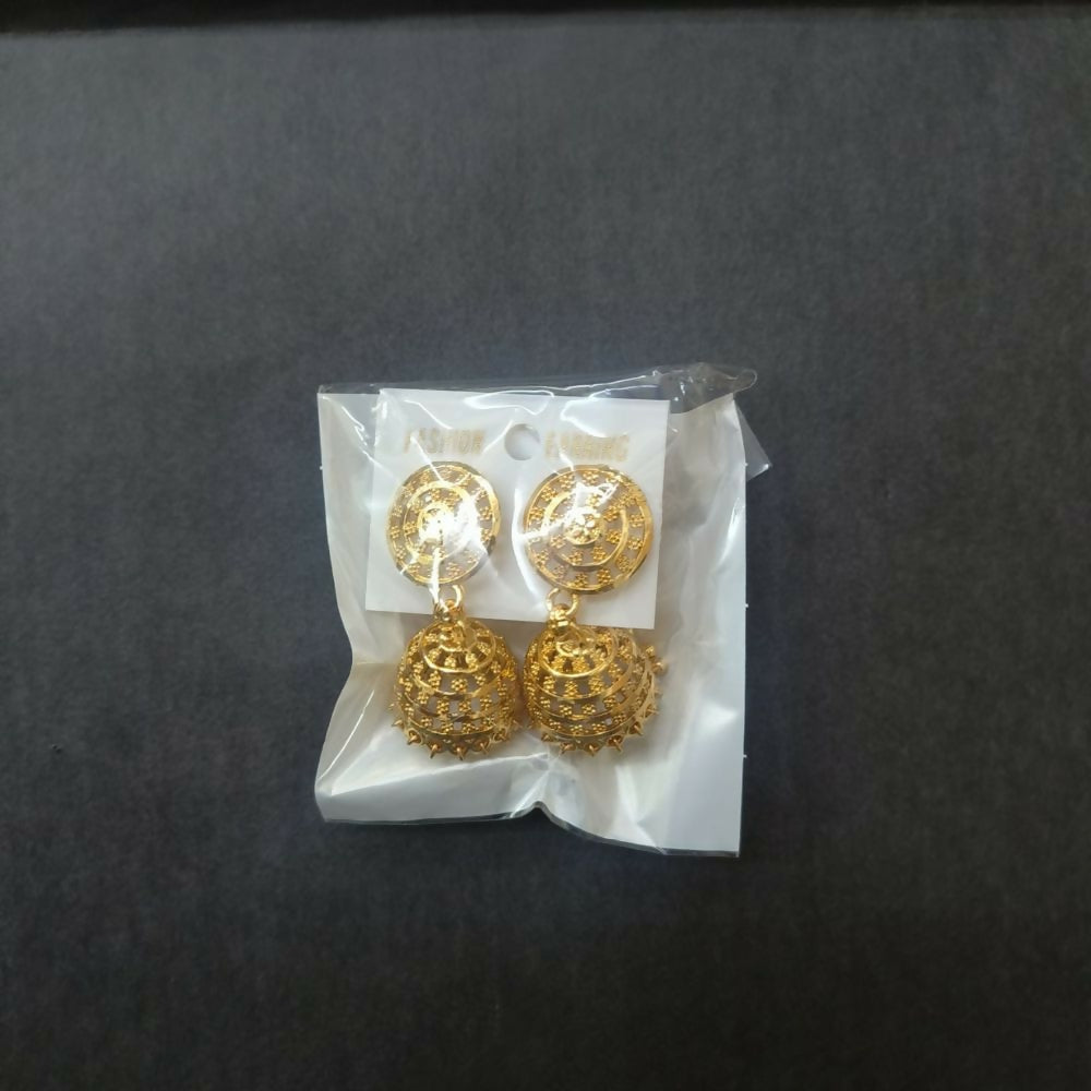 Gold tone jhumka earrings displayed on an earring holder