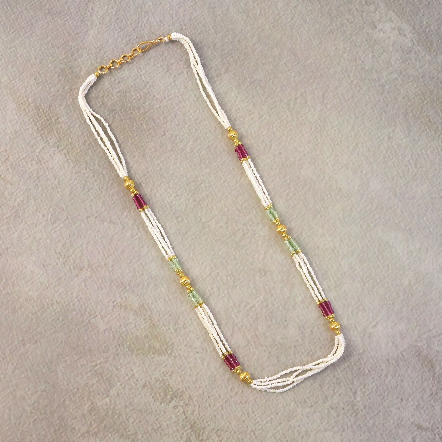 Side view of traditional mala necklace with layered beads and gold accents