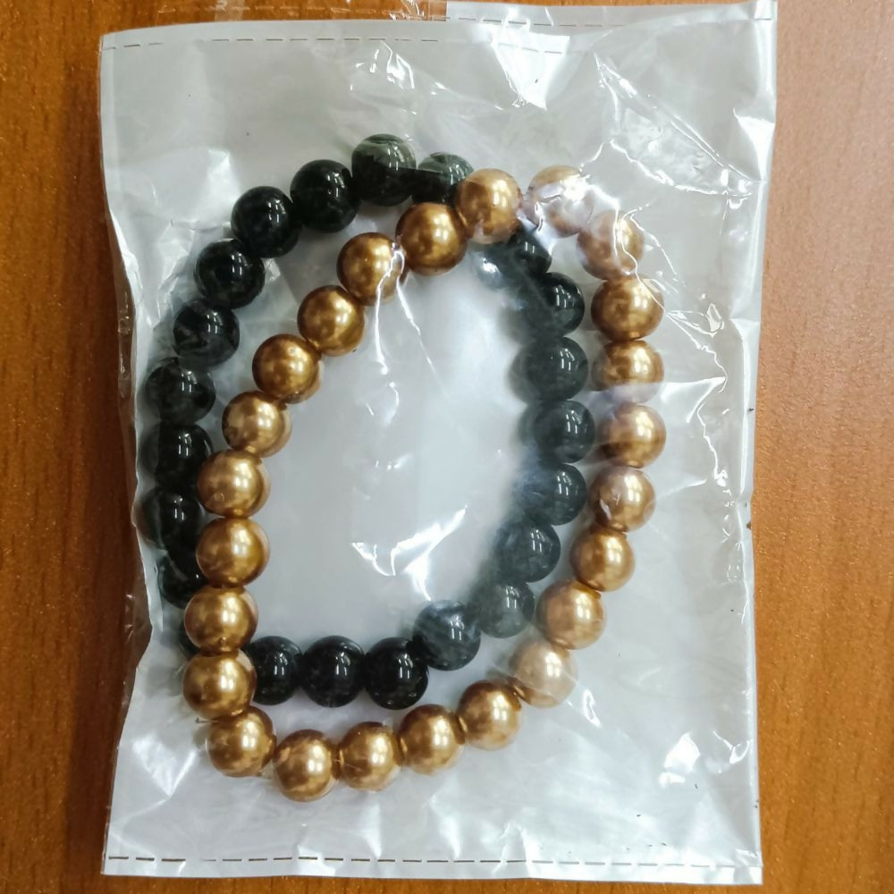 Black and gold accessory bracelet laid flat