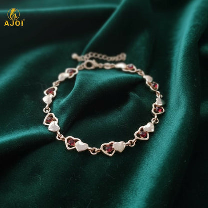 Gold finish heart crystal bracelet with pearl-style hearts and red crystals