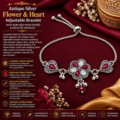 An antique silver adjustable slider bracelet with a central flower, two hearts, ruby-red pear stones, and dangling beads on