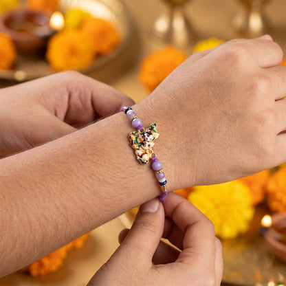 Close-up of bal krishna rakhi with beads and decorative centerpiece