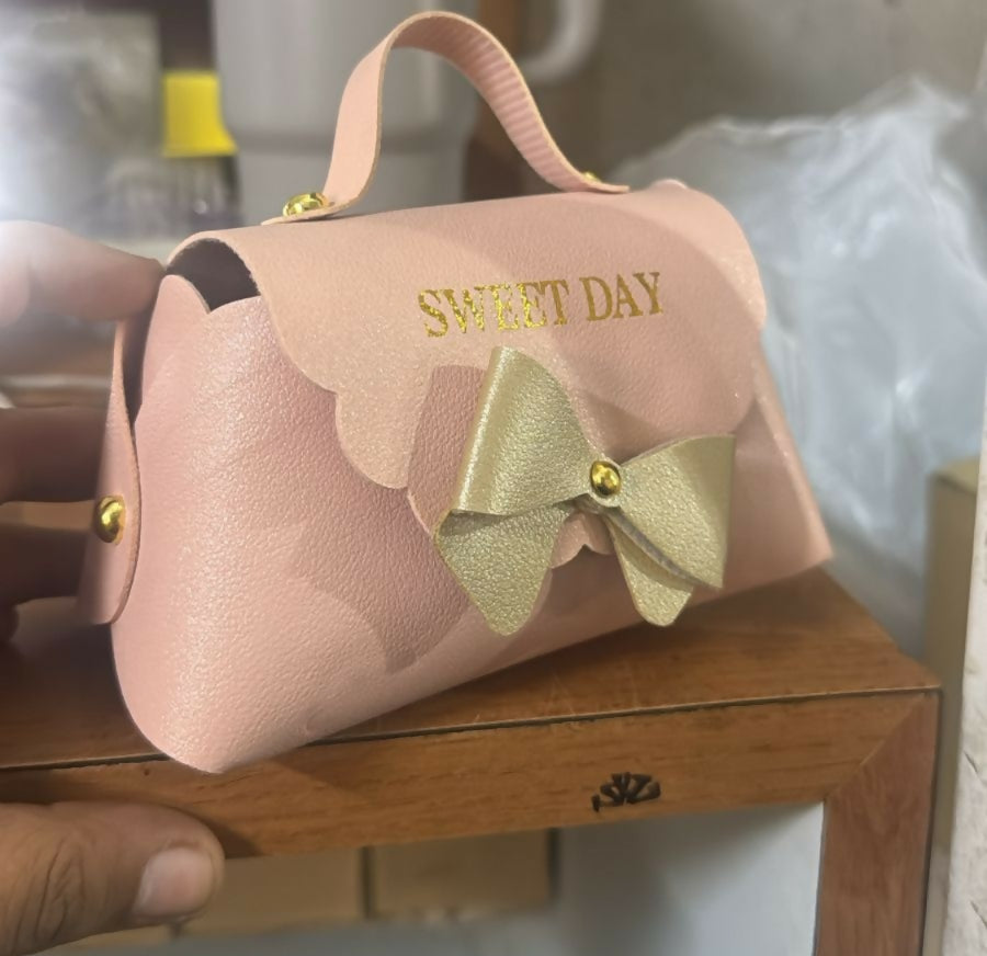 Pink mini handbag displayed on table