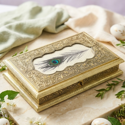 Close-up of intricate golden embossing and peacock feather detail on jewelry box