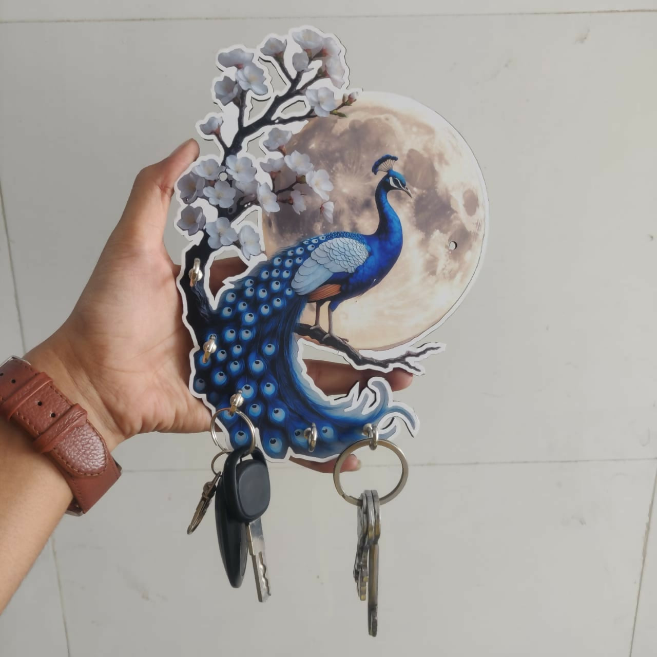 Wall-mounted wooden key holder with peacock and moon design