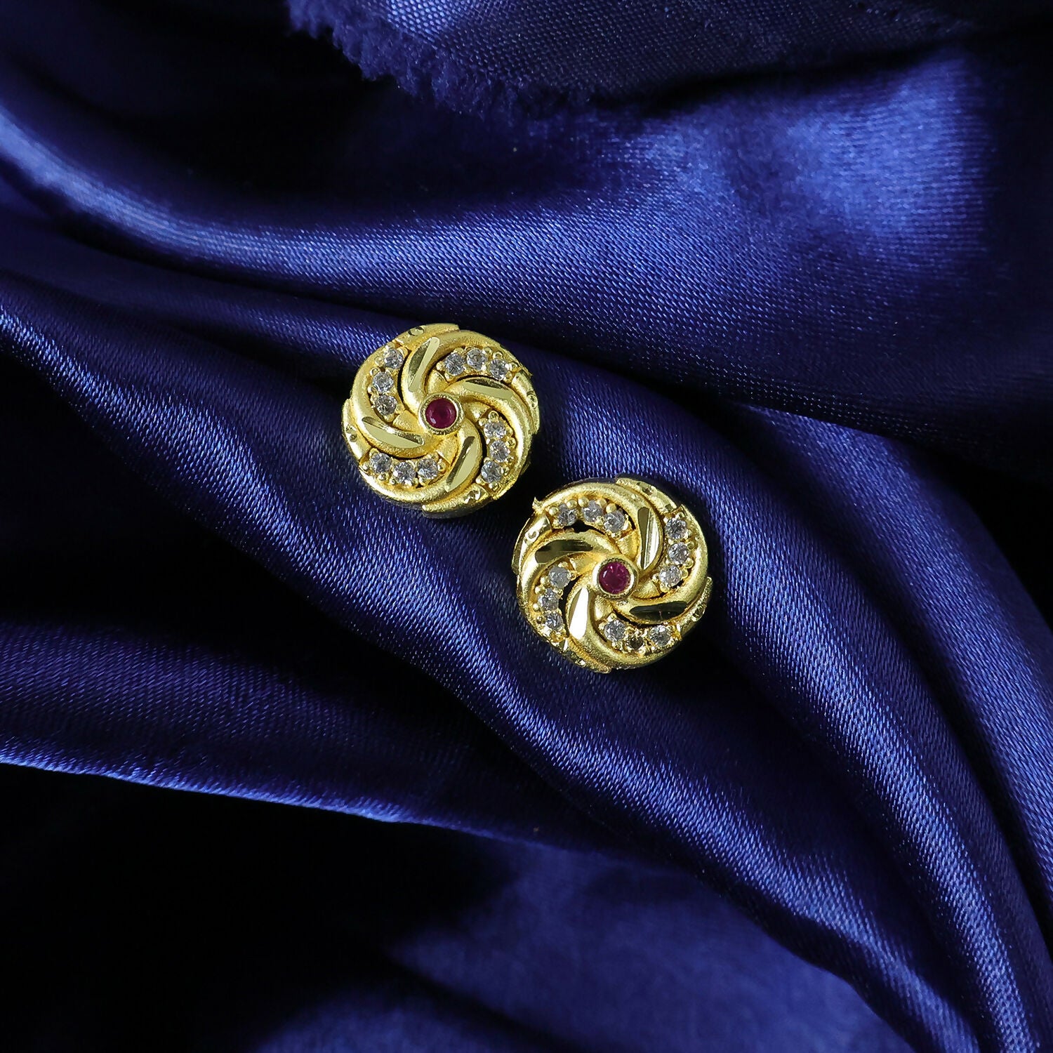 Elegant gold stud earrings featuring traditional spiral motifs