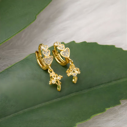 Front view of triple heart drop earrings with sparkling stone accents and gold finish