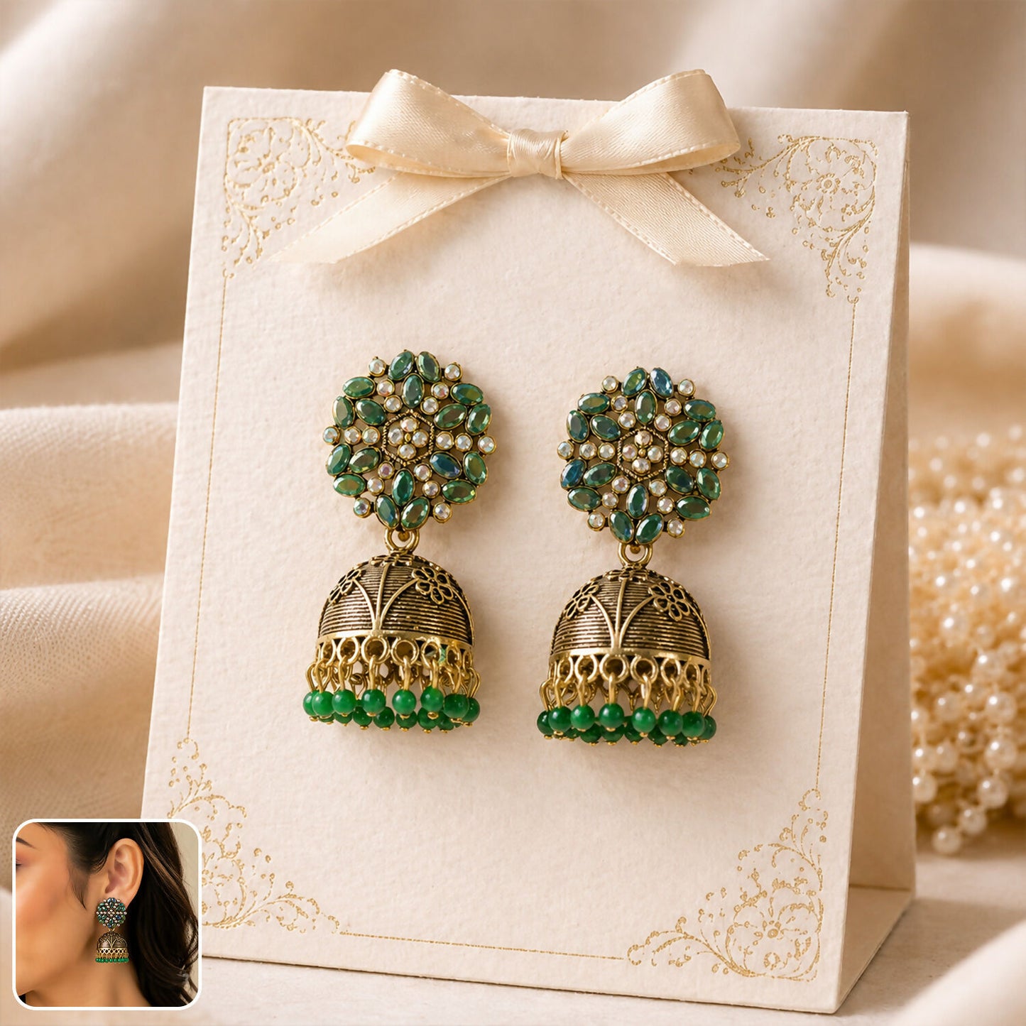 Front view of antique golden jhumka earrings with green stone floral top