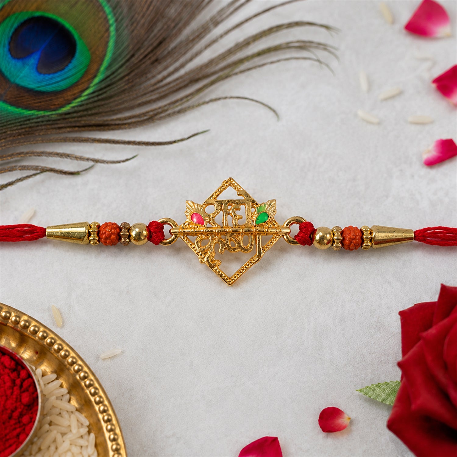 Golden Radha Krishna Rakhi with crystal beads, styled against a soft background.