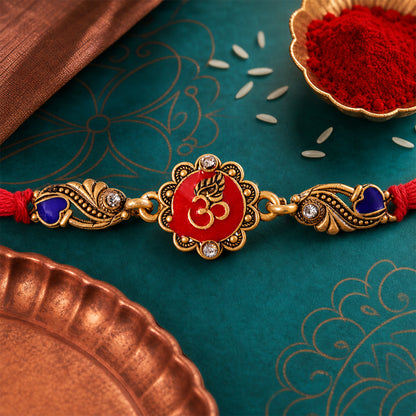 Traditional Rakhi showcasing Om Medallion, red stone accents and chain look for Gift