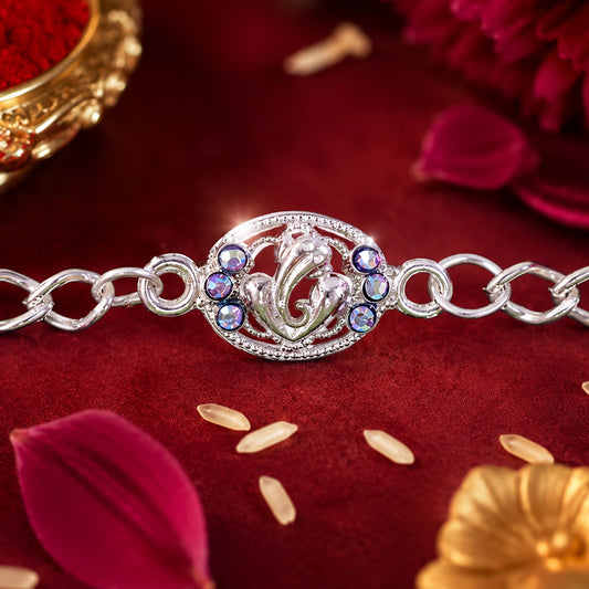 Close-up of silver Ganesha Rakhi chain bracelet with blue stones.