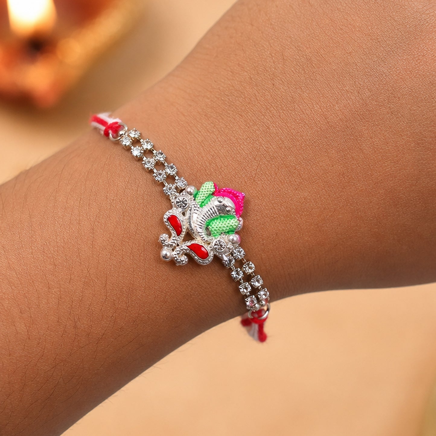 Silver-Toned Lord Ganesha Rakhi with Pink-Green Enamel, Double Crystal Chain & Red-White Thread