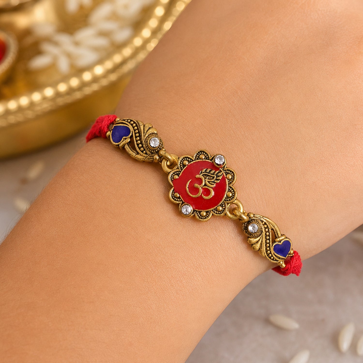 Traditional Rakhi showcasing Om Medallion, red stone accents and chain look for Gift