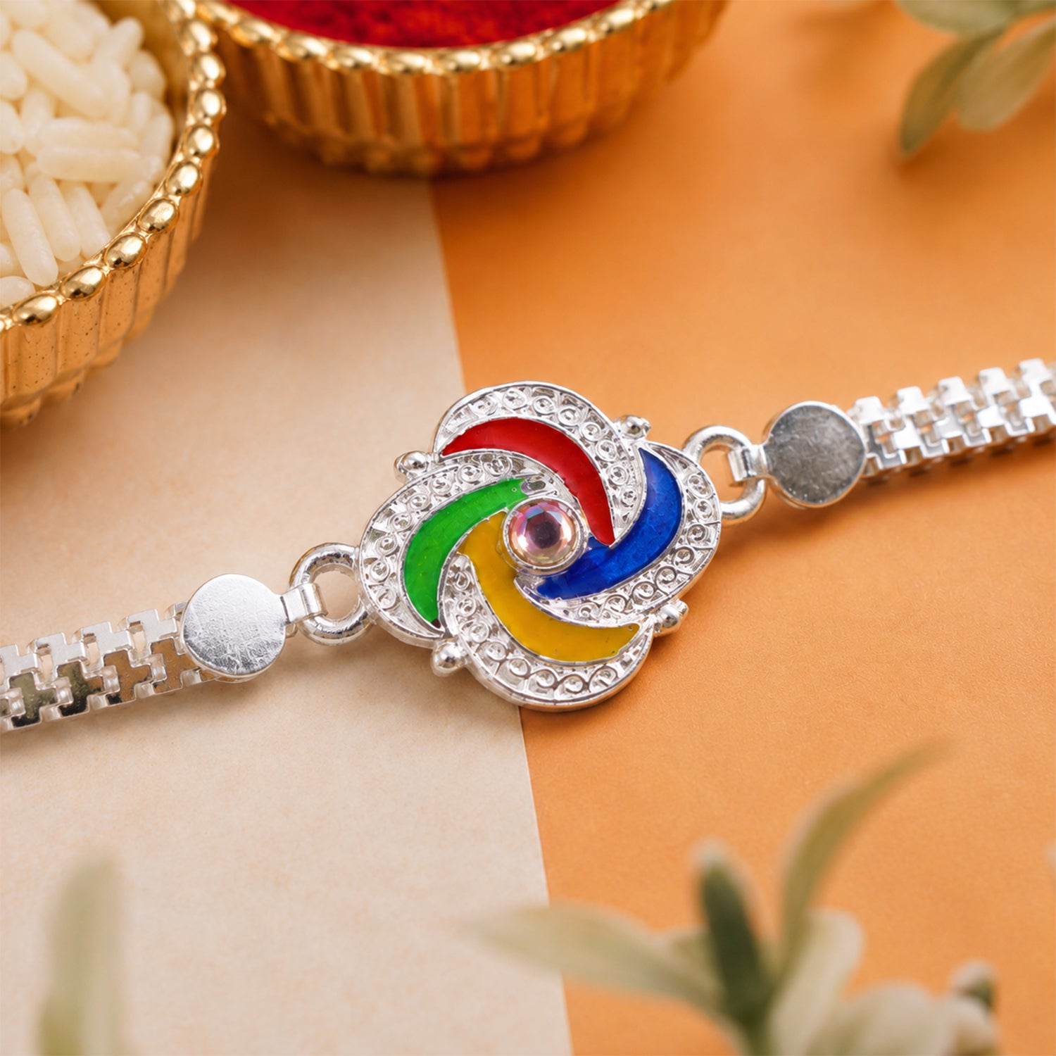 Close-up of the intricate feather and silver chain design of the Rakhi.