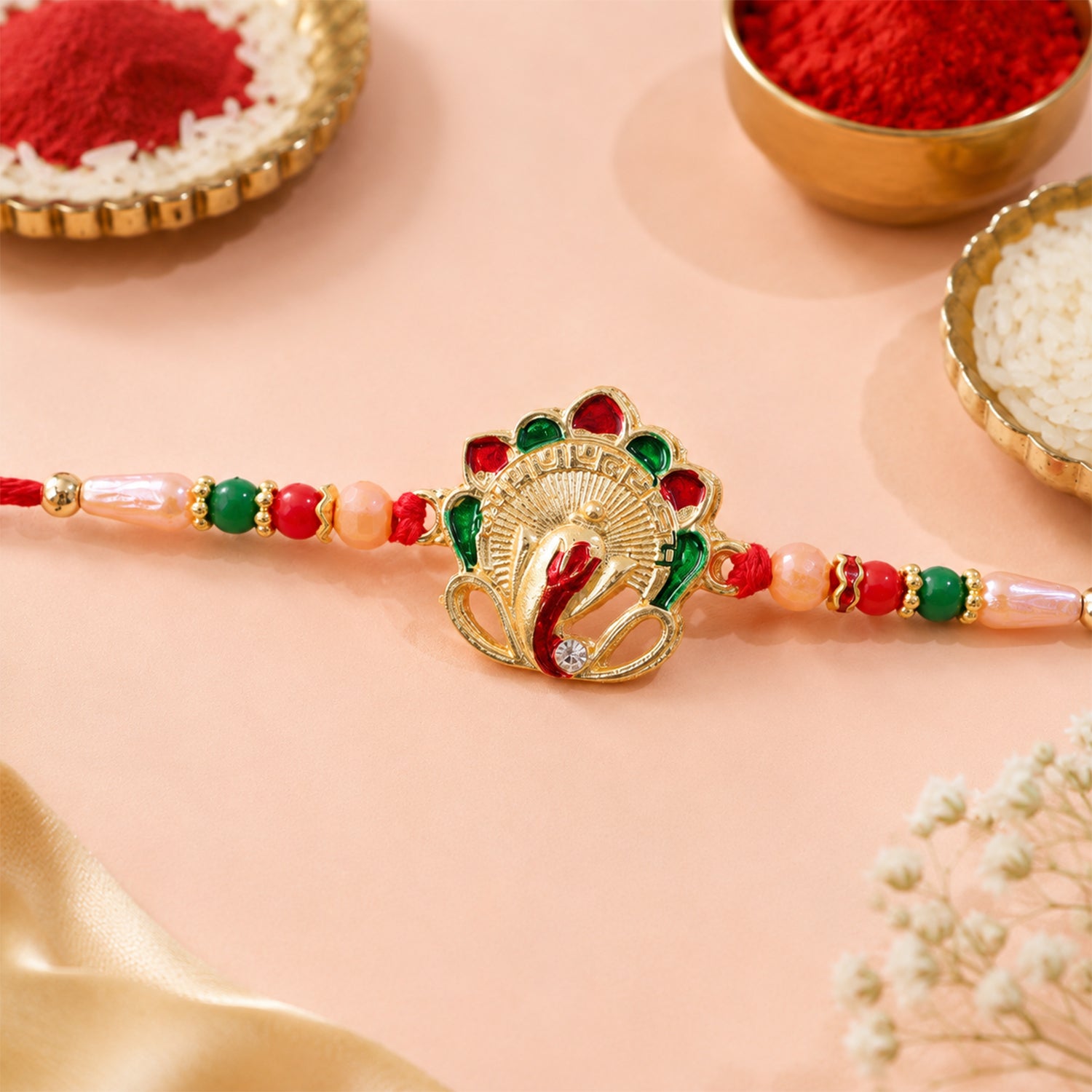 Om Ganesha Rakhi with intricate beadwork and sacred Om symbol on a white background.