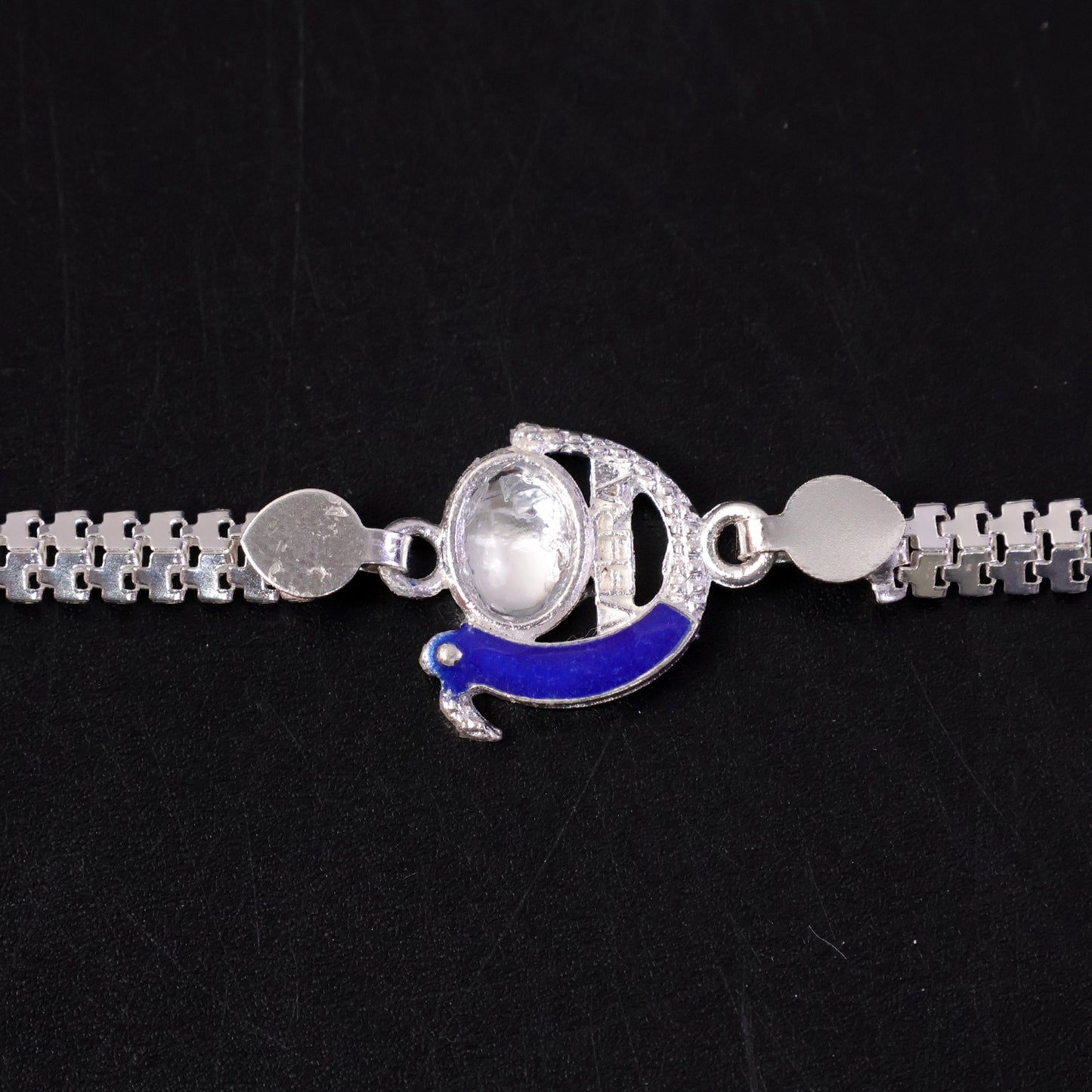 Side view of the silver chain and peacock design Rakhi.