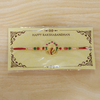 Om Ganesha Rakhi presented on a festive plate with traditional puja essentials.