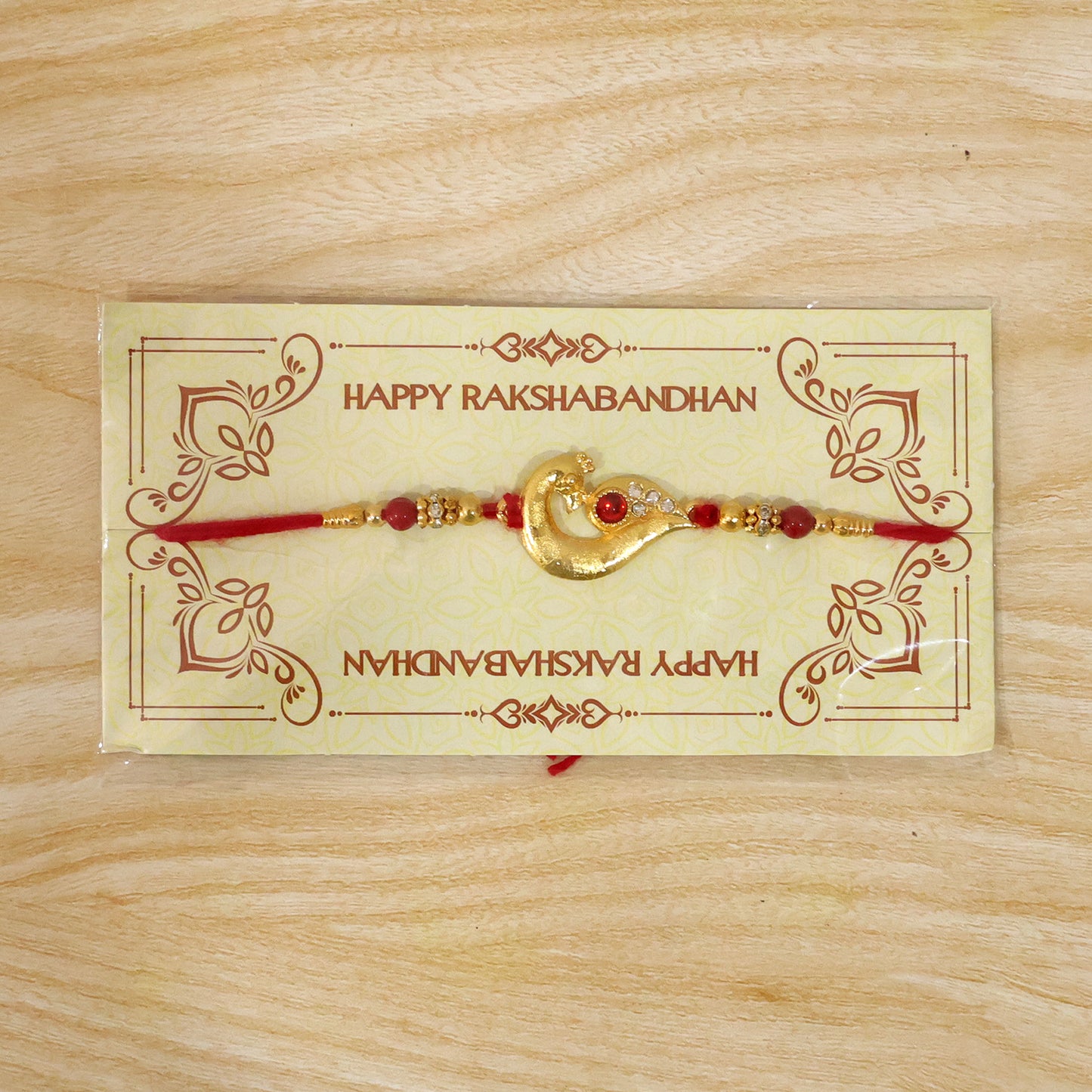 Peacock Feather Rakhi – Golden & Kundan Detailed Red Thread