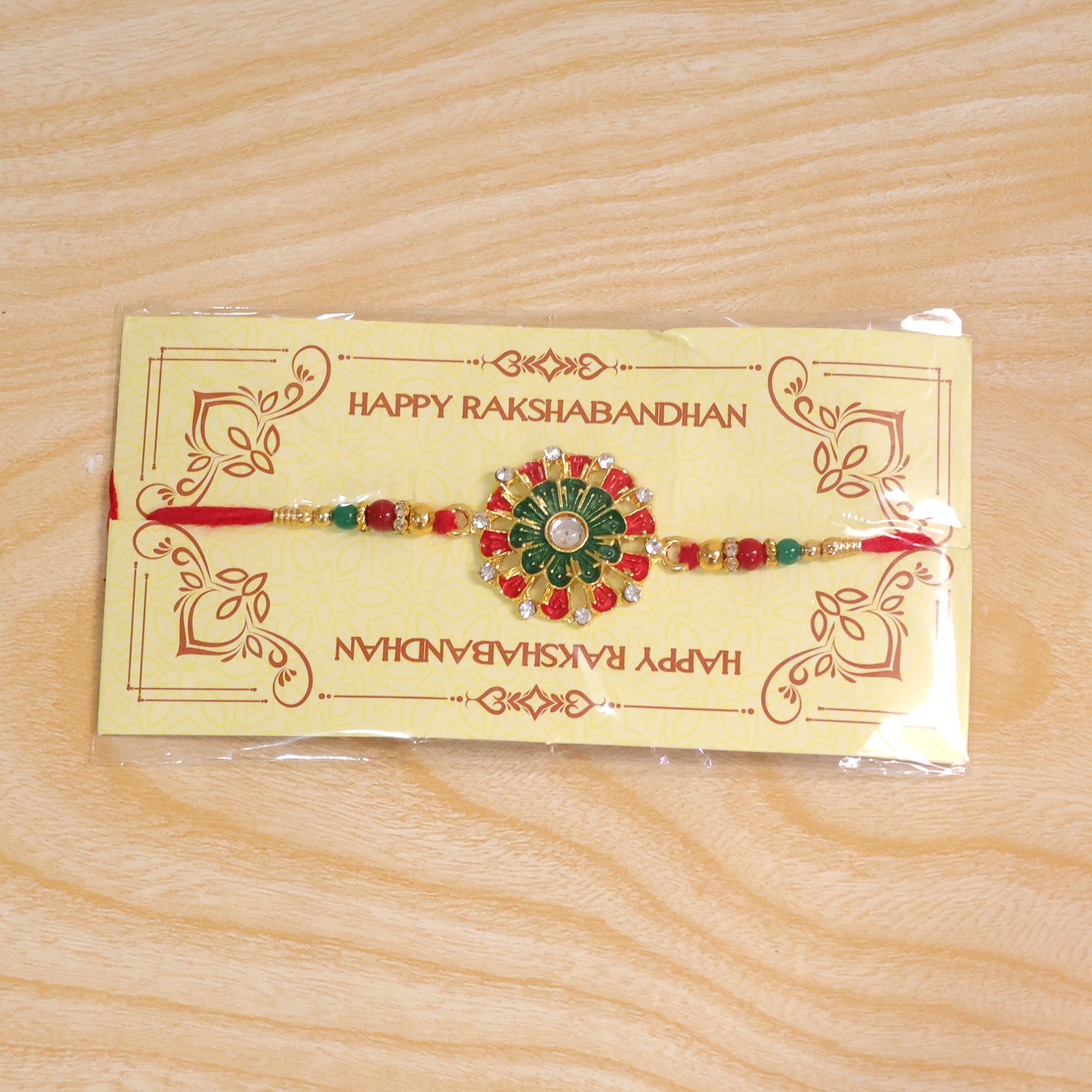 Detailed view of the red green beads and stone accents on the traditional Rakhi.