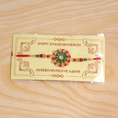 Detailed view of the red green beads and stone accents on the traditional Rakhi.