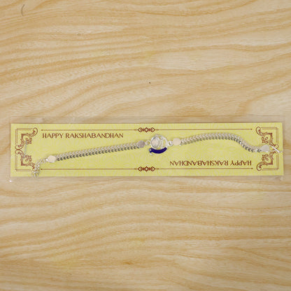 Peacock Rakhi presented on a simple surface, highlighting its details.
