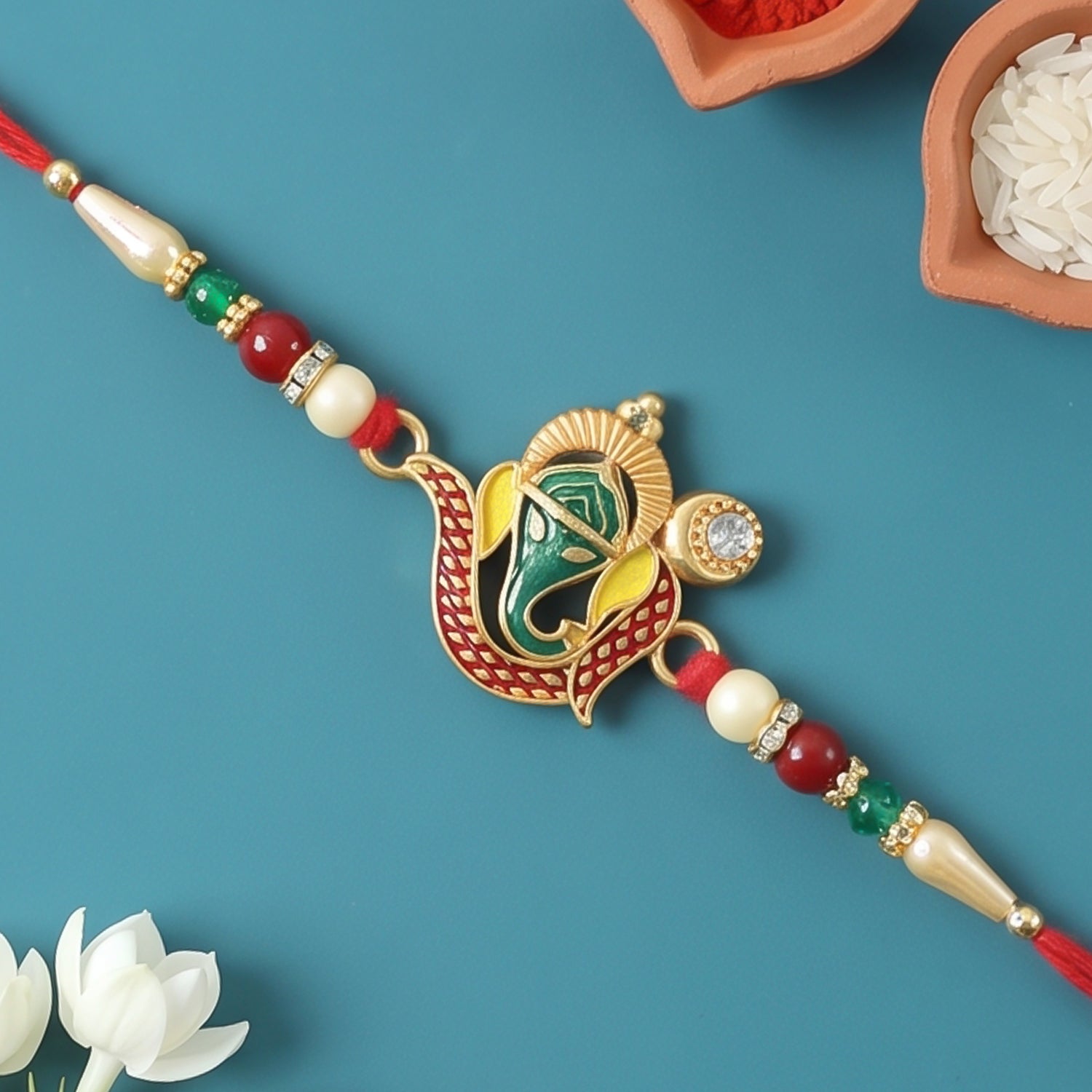 Ganesha Rakhi with intricate green and gold design, ready for Raksha Bandhan.