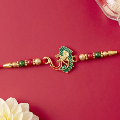Close-up of the sacred Om symbol and vibrant peacock feather on the Rakhi thread.