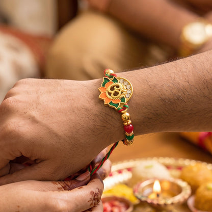Lotus Om Pendant Rakhi with Orange Petals and Kundan Stones