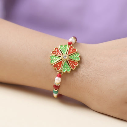 Side view of traditional rakhi showing intricate floral design and pearl beads.