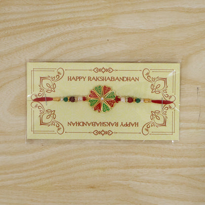 Angled view of the traditional rakhi showcasing its crystal and pearl details.