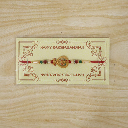 A red thread bracelet with a gold-colored, intricate charm and colorful beads, displayed on a