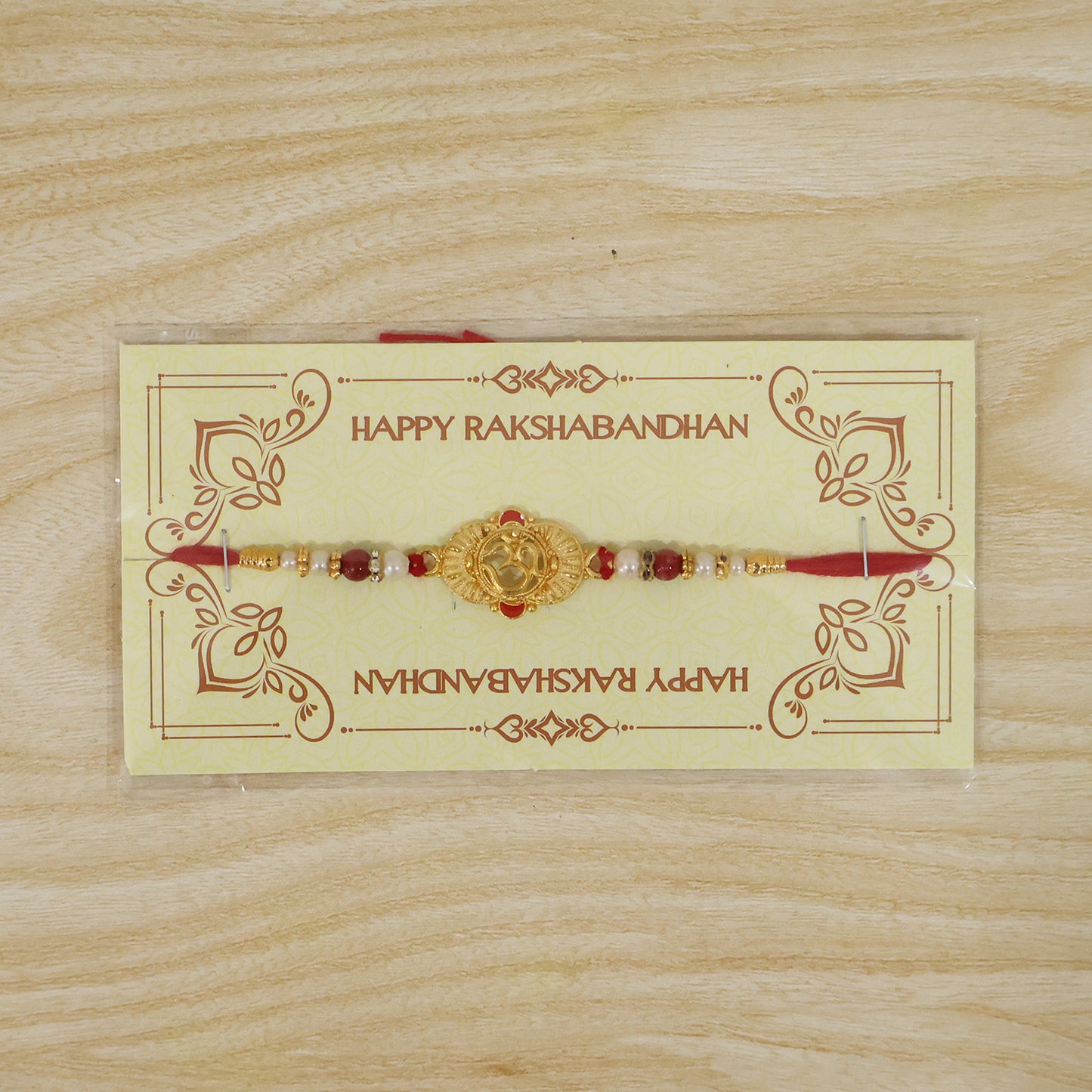 Ganesha Rakhi with green enamel and golden details, presented as a festive gift.