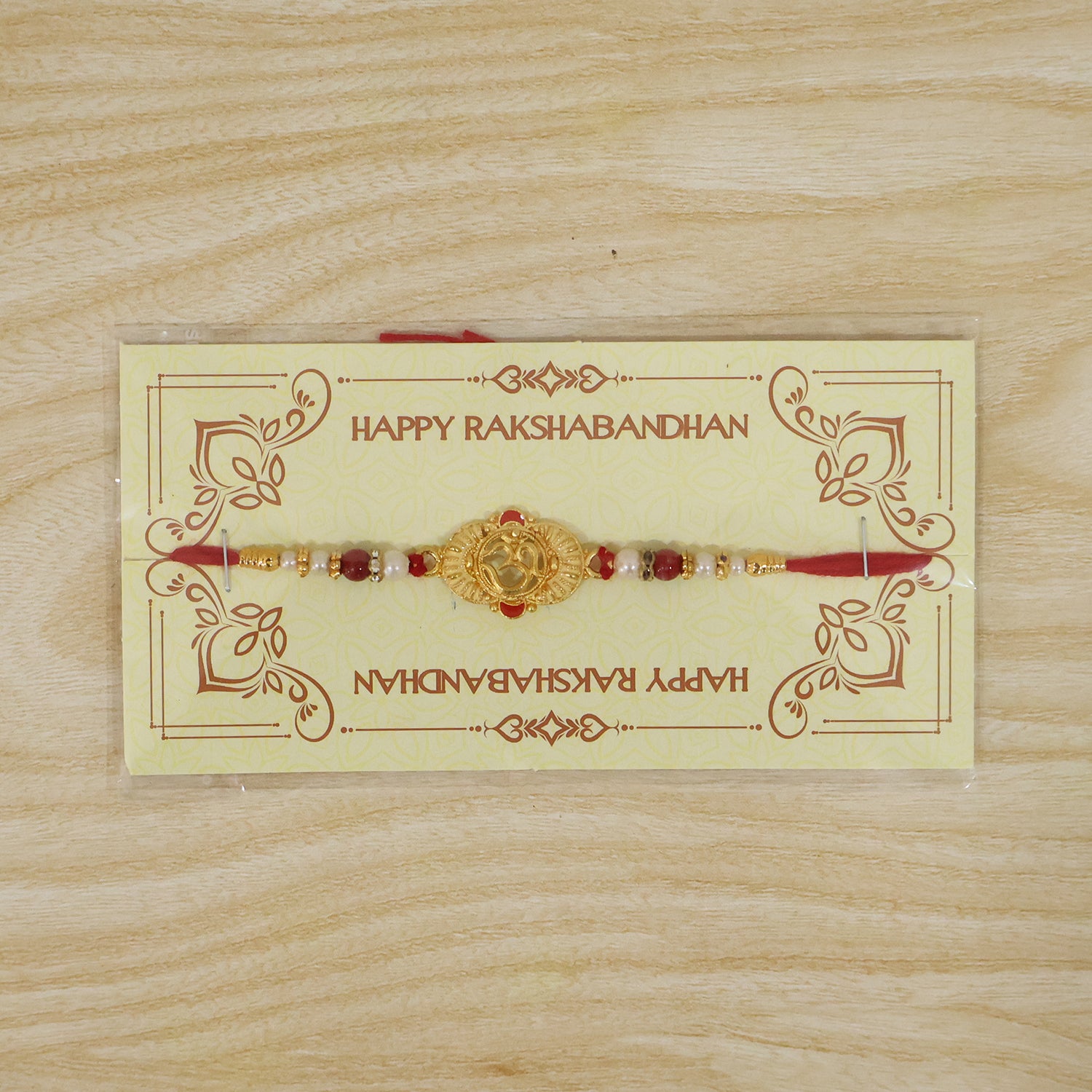 Ganesha Rakhi with green enamel and golden details, presented as a festive gift.